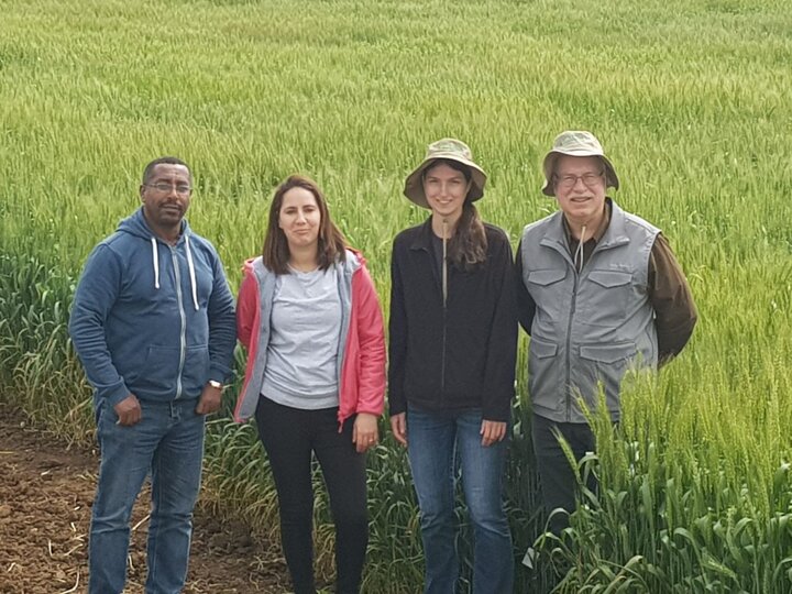 Four adults standing in field